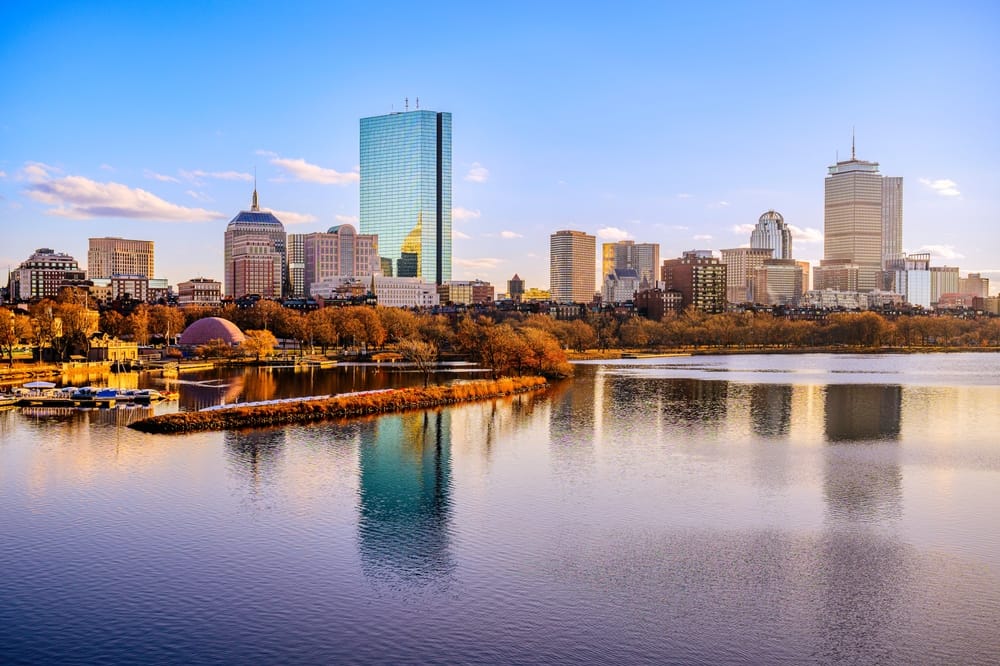 Boston City Skyline over the Charles River in Massachusetts, USA. A tranquil riverscape of Back Bay with golden illuminated wintery foliage in New England.