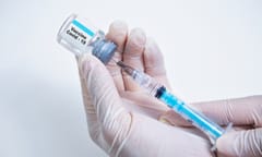 Person drawing Covid-19 vaccine from the vial into a needle