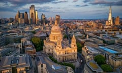 Aerial summer sunset view of the skyline of London, England, with St. Pauls Cathedral, city skyscrapers and river Thames with golden sunlight