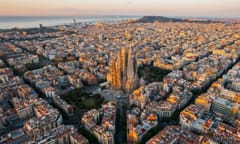 Aerial view of Barcelona Eixample residential district and Sagrada Familia Basilica at sunrise. Catalonia, Spain. Cityscape with typical urban octagon blocks