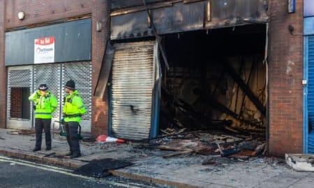 Sunderland, UK - August 3rd 2024: Police stand guard at the Sunderland Citizens Advice Bureau after it is burnt out following a night of rioting by the Far-Right.