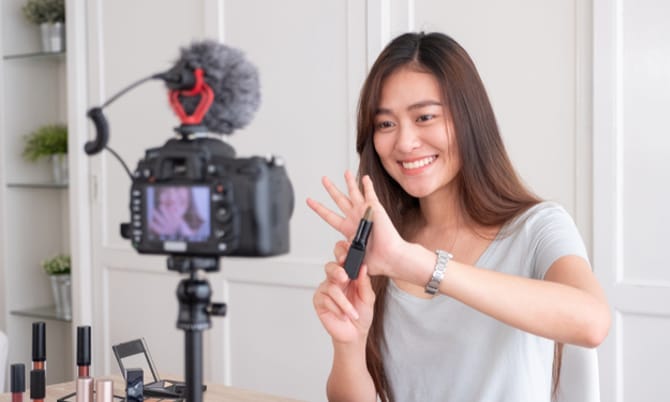 Asian young female blogger recording vlog video with makeup cosmetic at home online influencer on social media concept.live streaming viral
